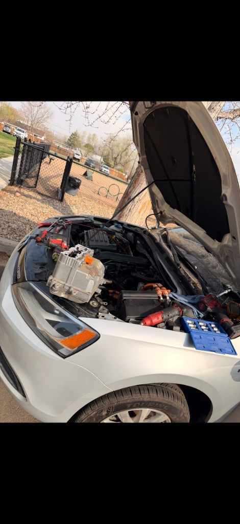 Mobile mechanic working under the hood on location